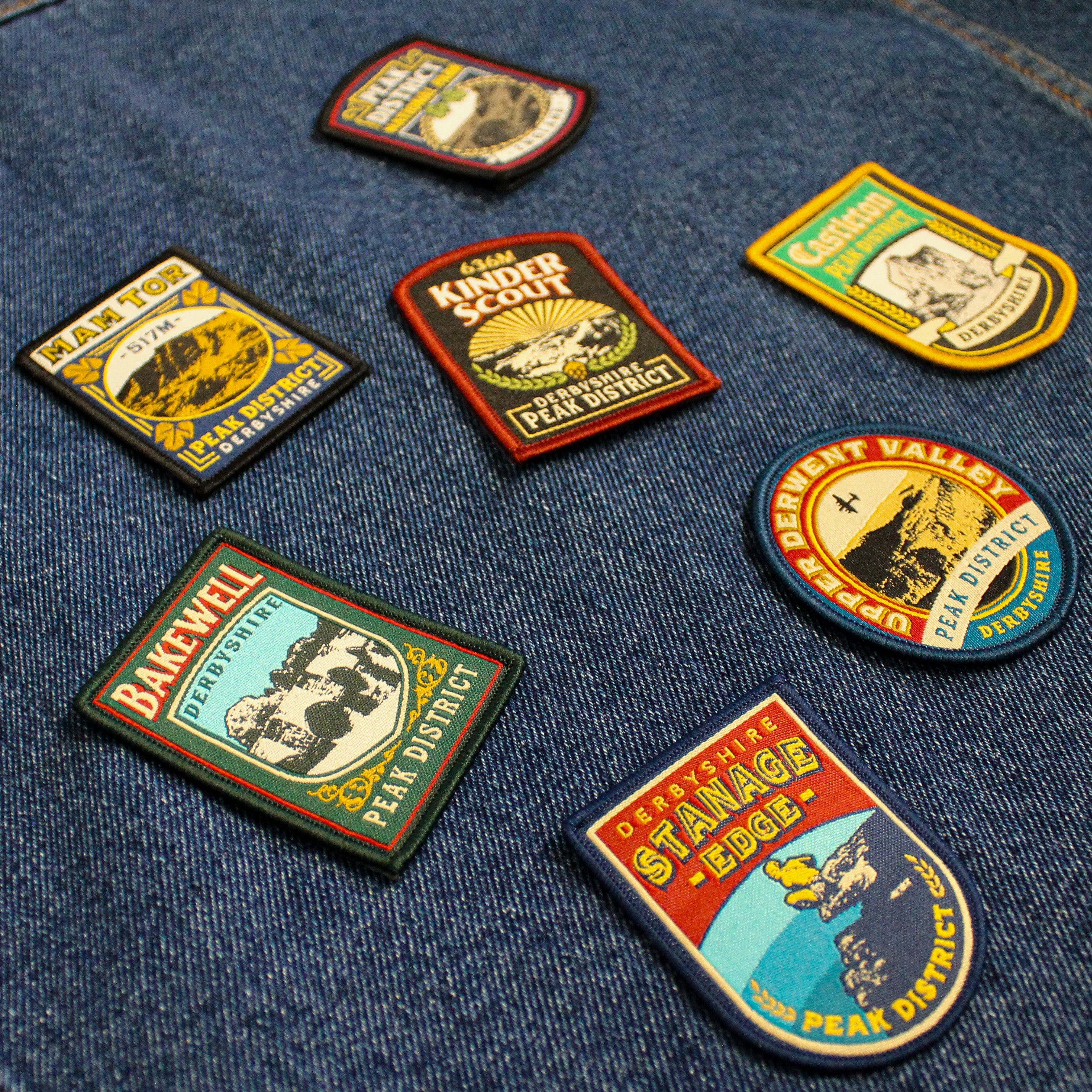 Collection of vintage-style patches from iconic locations in the Peak District on a denim background