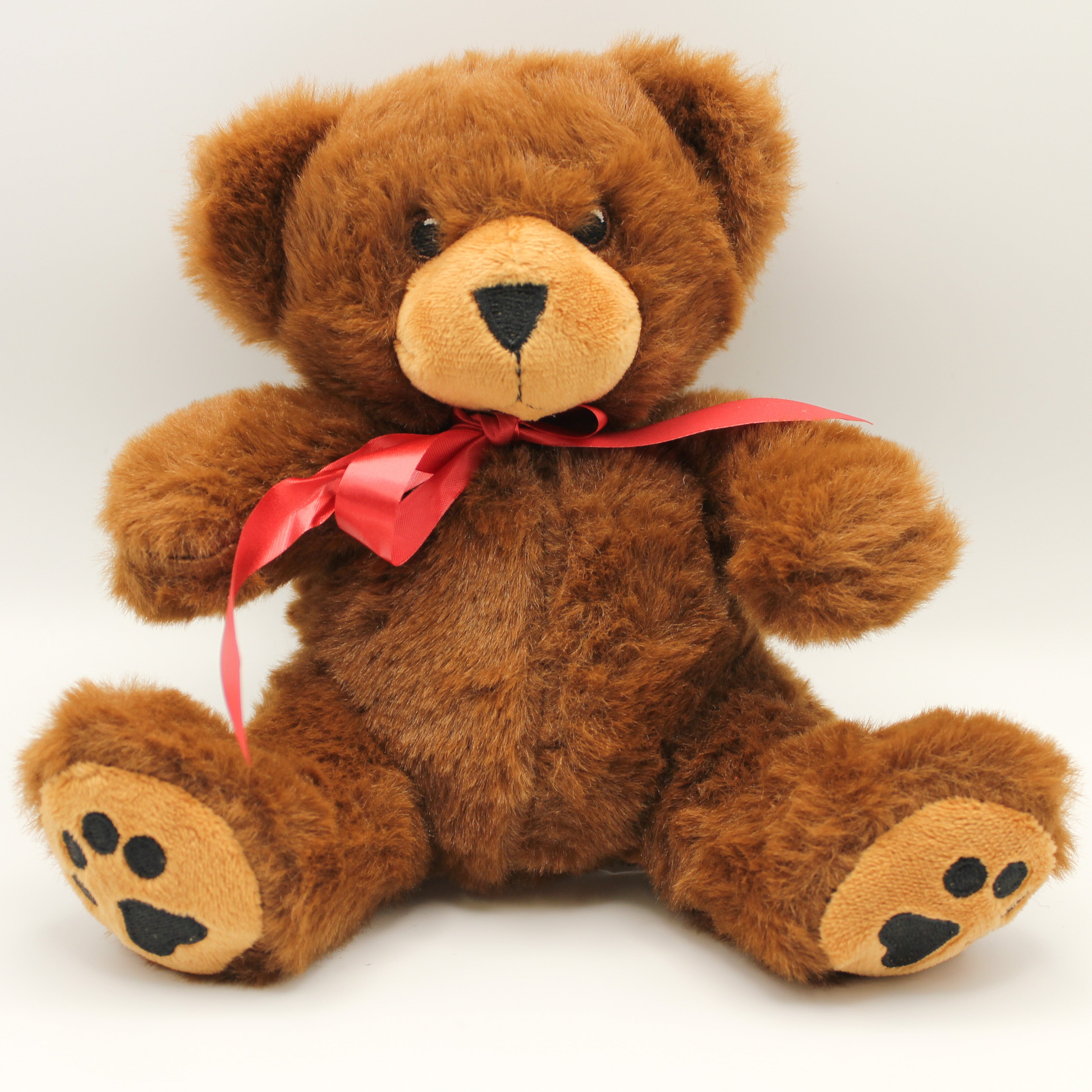 Brown teddy bear with a red ribbon on a white background